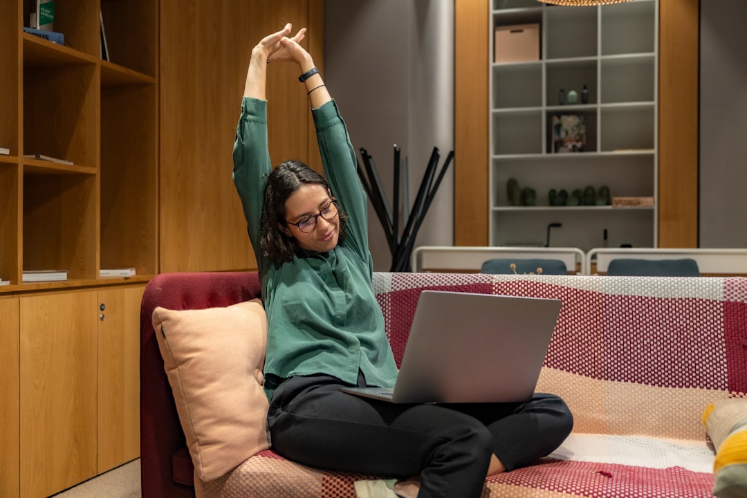 Young woman stretching while doing remote work in relaxing office environment