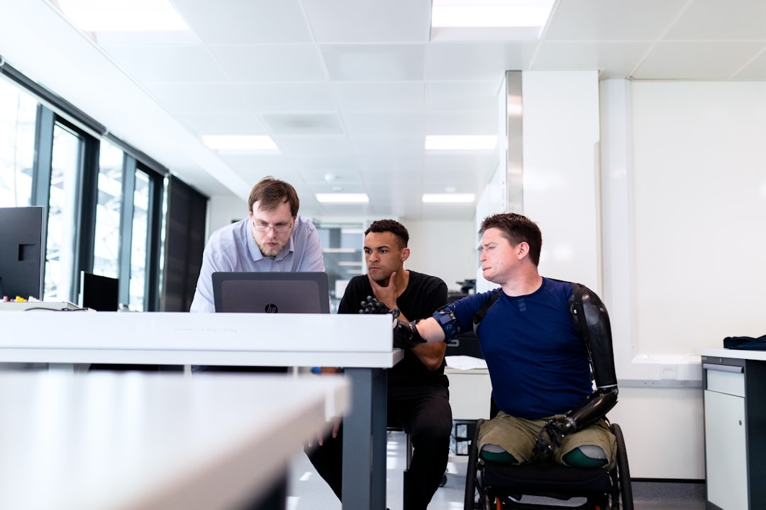 Engineers look at computer screen with prosthetic limb user